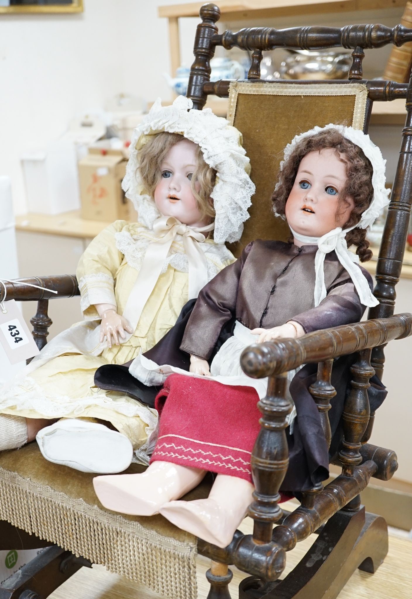 A Heubach, Koppelsdorf 250 bisque doll and an Armand Marseille 390 bisque doll, seated in turned beech rocking armchair, 73cm